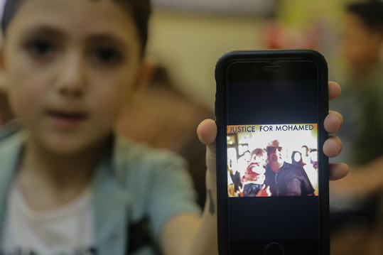 fares_holds_the_phone_with_his_last_picture_with_his_father_before_the_arrest.jpg