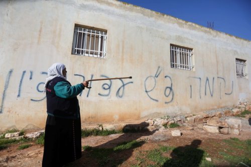palestinienne_pres_de_sa_maison_graffiti_hebreu.jpg